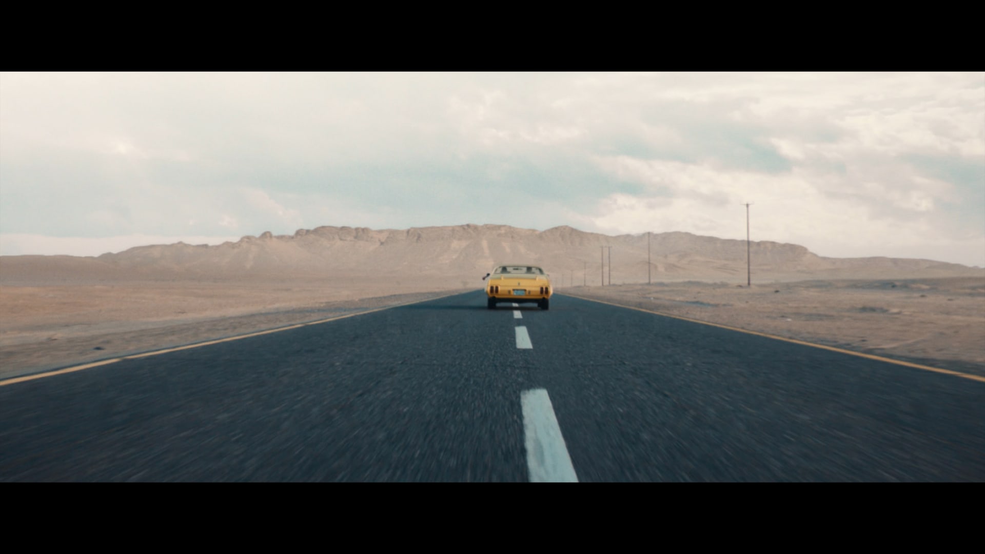 A still from Ahli United Bank’s Al-Hassad TVC, which shows a seventies American muscle car driving in the middle an empty road, of what looks to be the Nevada desert