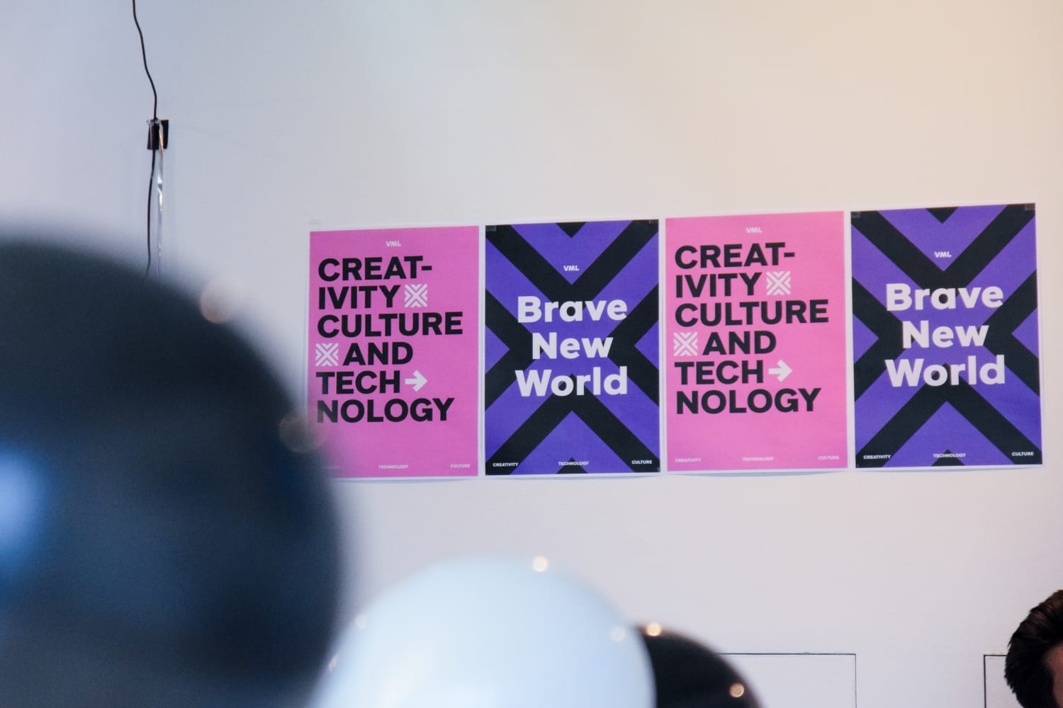 Pink and purple posters on the wall with the words "Brave new world" and "creativity, culture and technology"