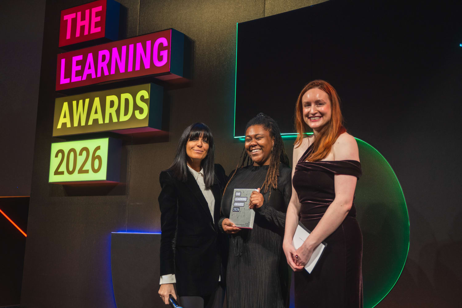 Sophia Newman from VML Enterprise Solutions is pictured with two other individuals, holding a trophy from the LPI Awards