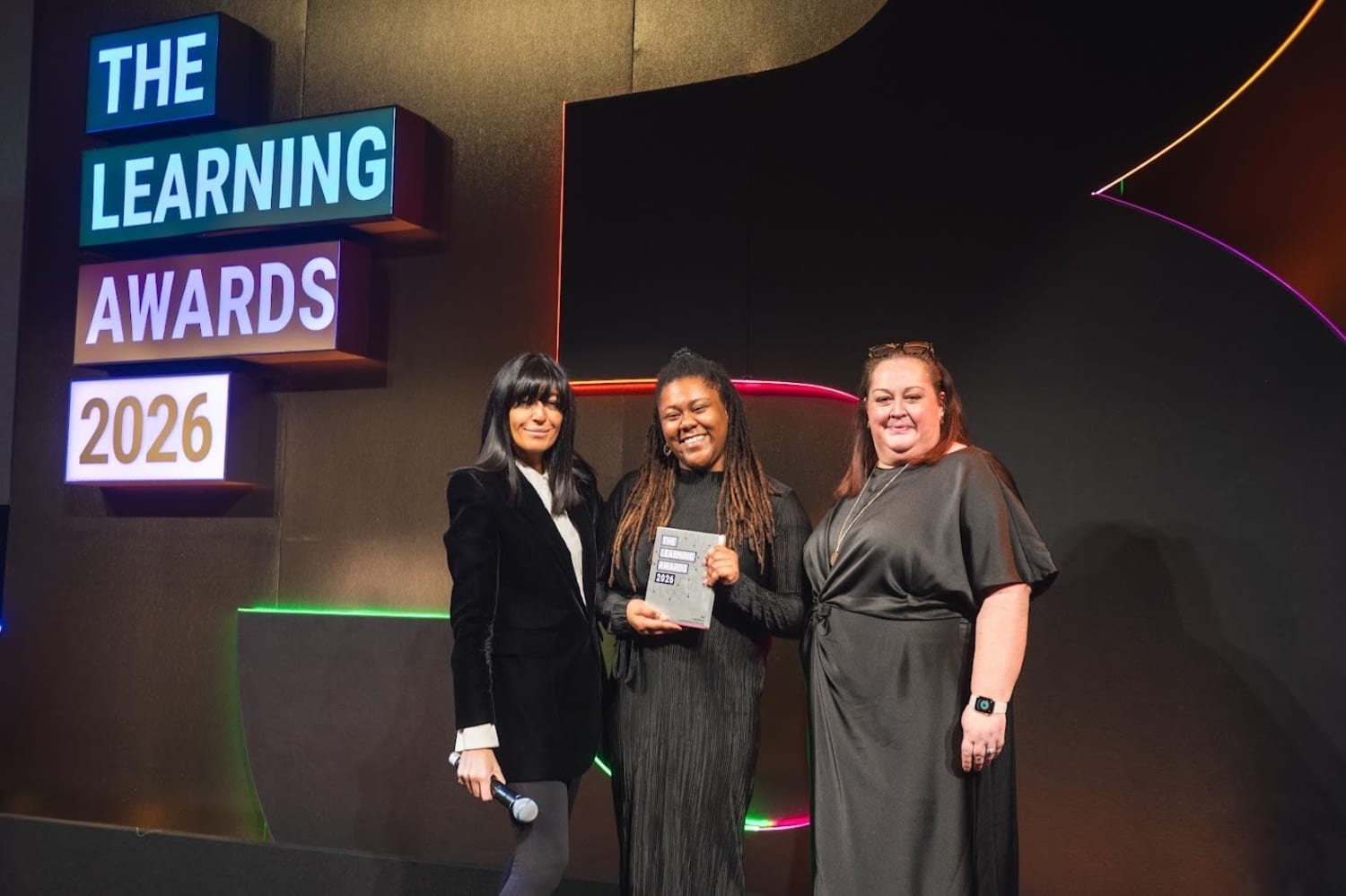Sophia Newman from VML Enterprise Solutions is pictured with two other individuals, holding a trophy from the LPI Awards