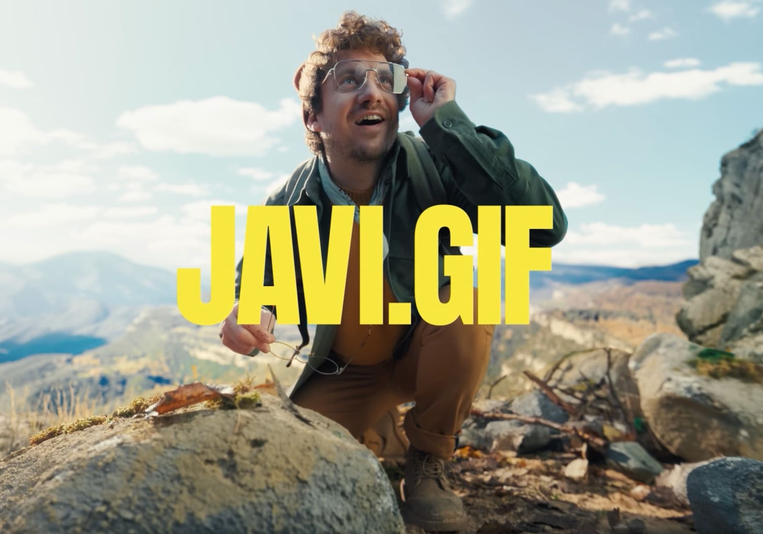 Image of Javi wearing glasses and other pair in his right hand holiding them.