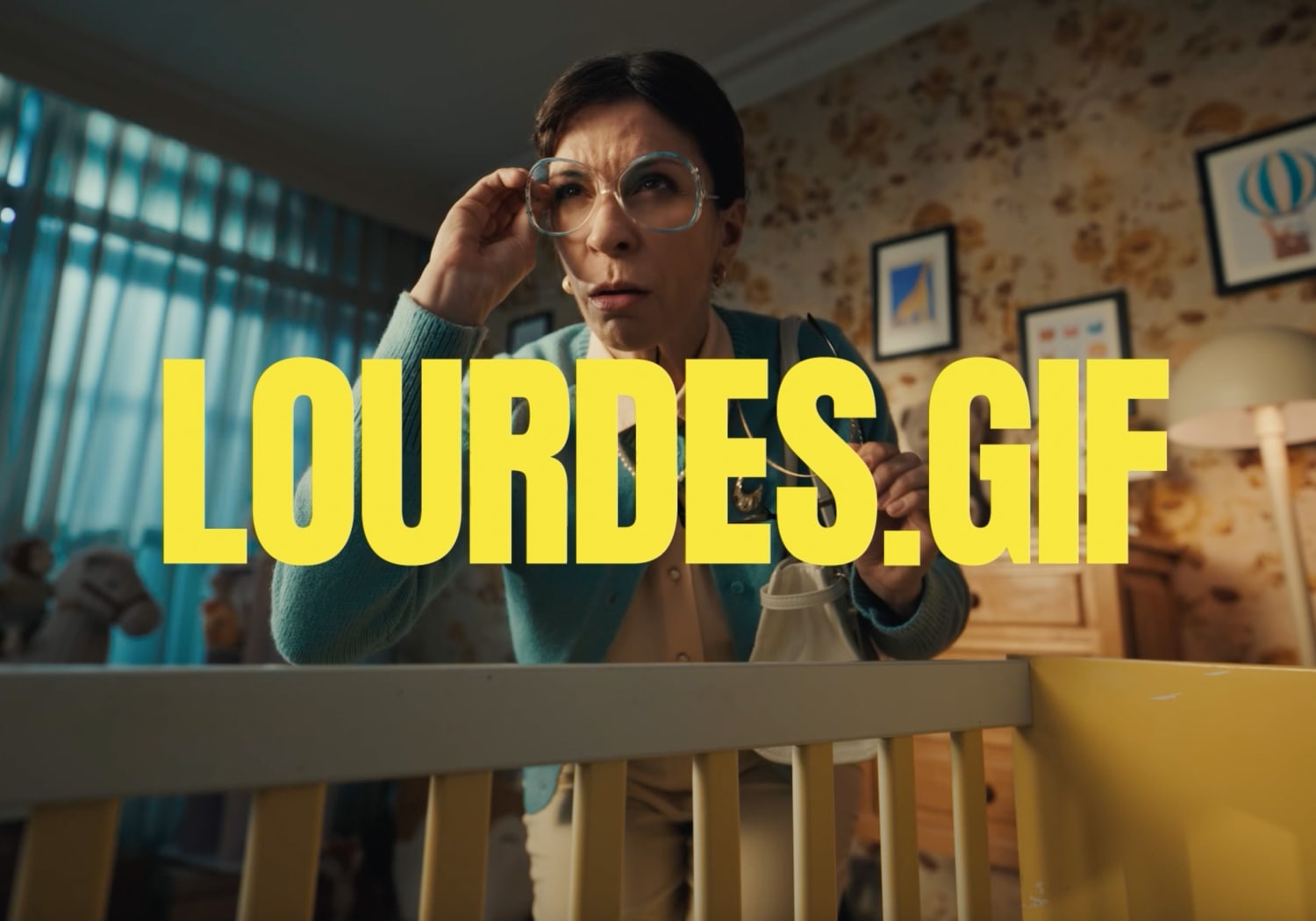 Image of Lourdes wearing glasses and other pair in his right hand holiding them.