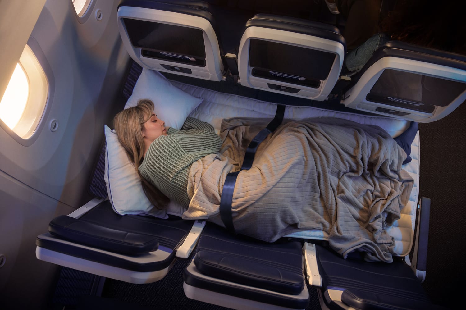 United Airlines’ Relax Row transforms a standard row of three economy seats into a couch-like sleeping space. Courtesy of United Airlines