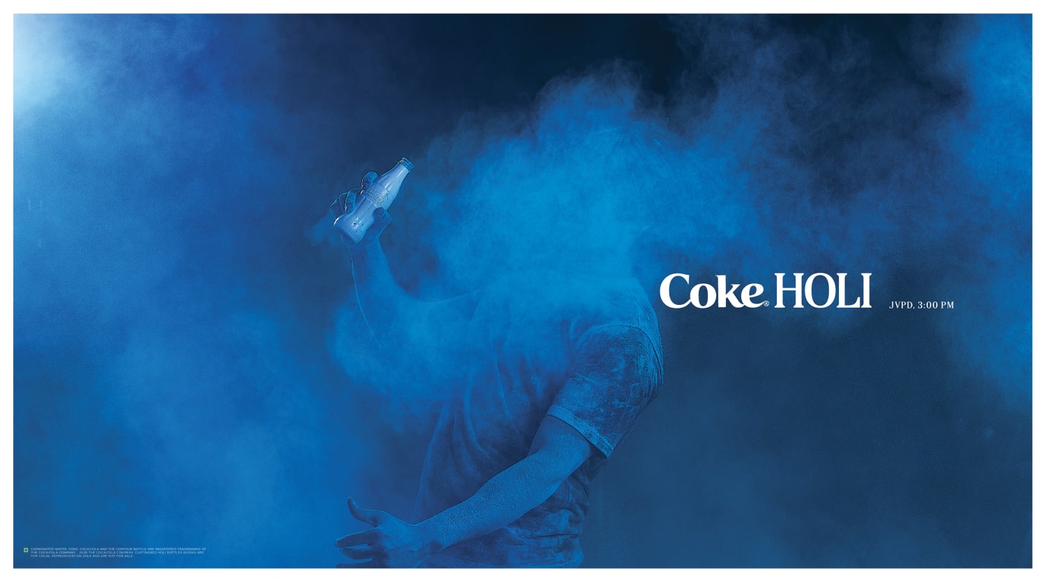 Participant covered in blue Holi colour holding a white Coca Cola bottle during the campaign