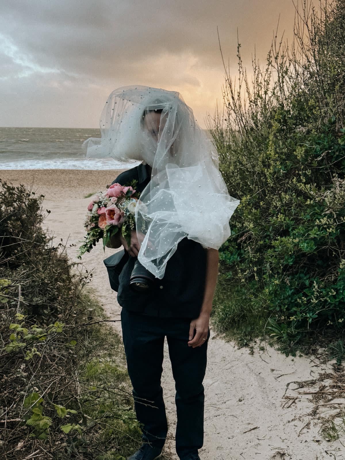 Jamie Nicholls photographing a wedding, camera in hand