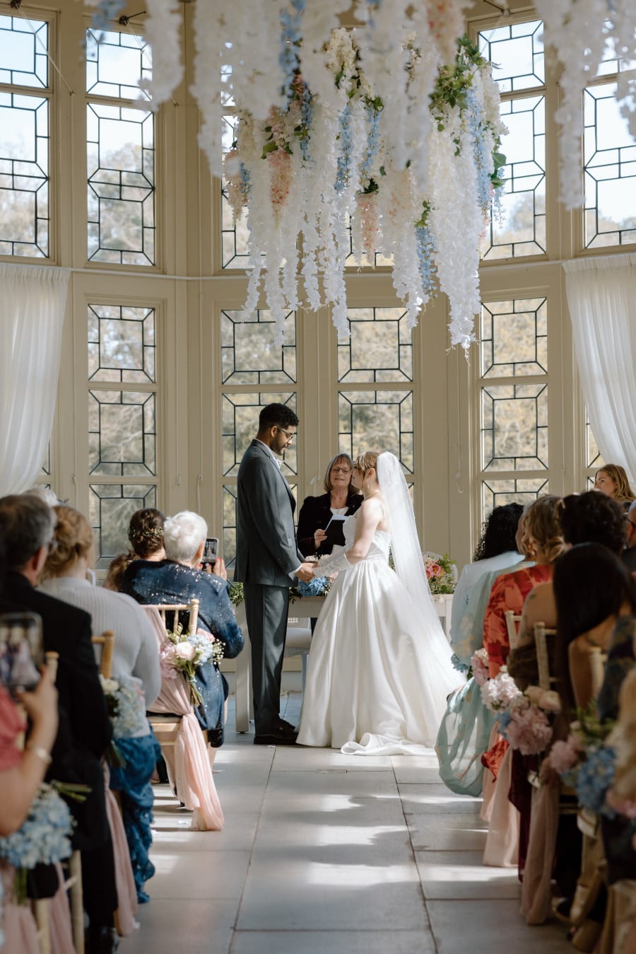 The ceremony beneath hanging blossom in the great hall, Highcliffe Castle, Christchurch