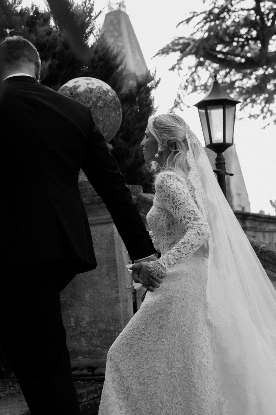 Morgan and Josh walking past a lamp post as the light drops, in black and white, The Cotswolds