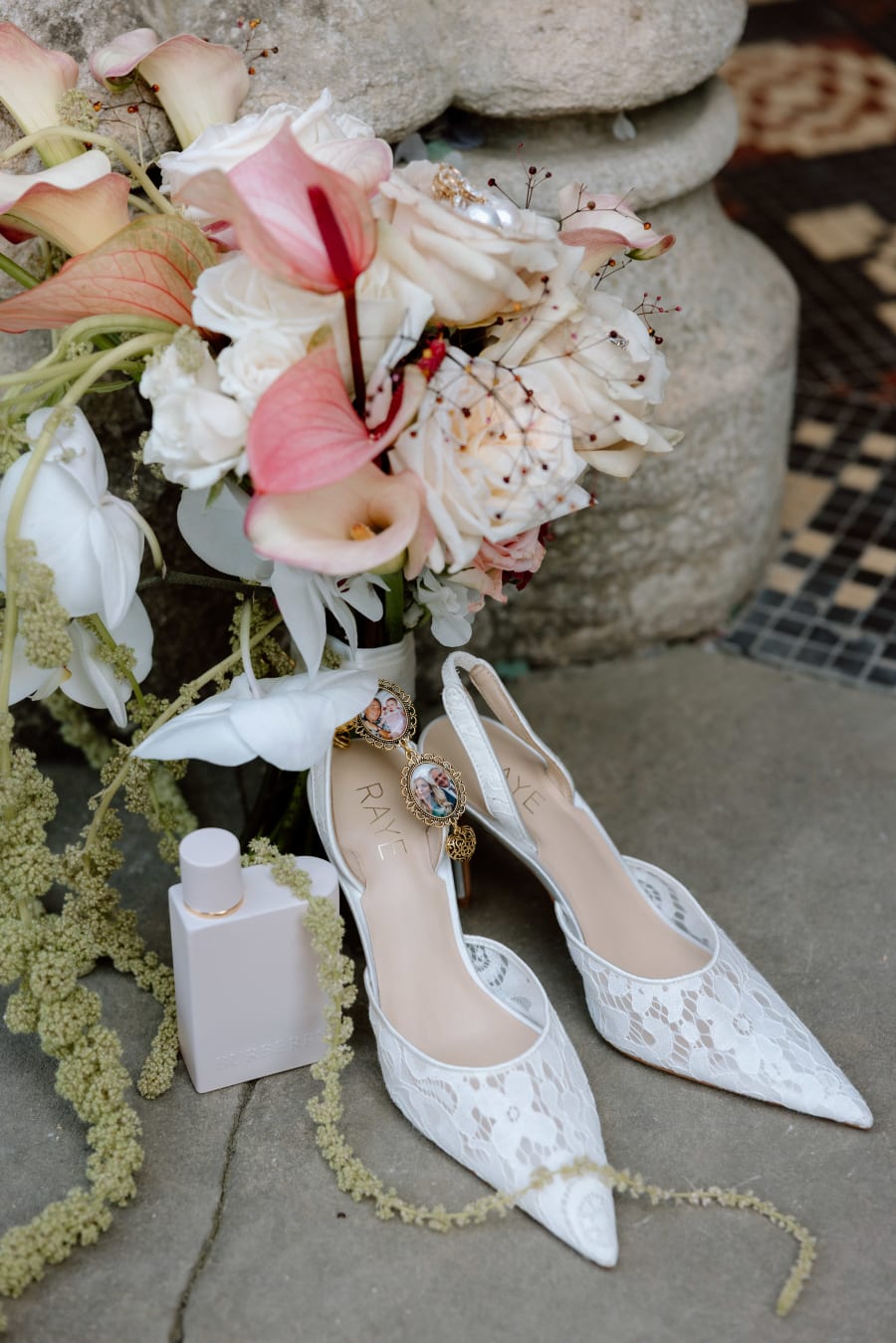Lace shoes, perfume and the bridal bouquet laid out on stone, The Cotswolds