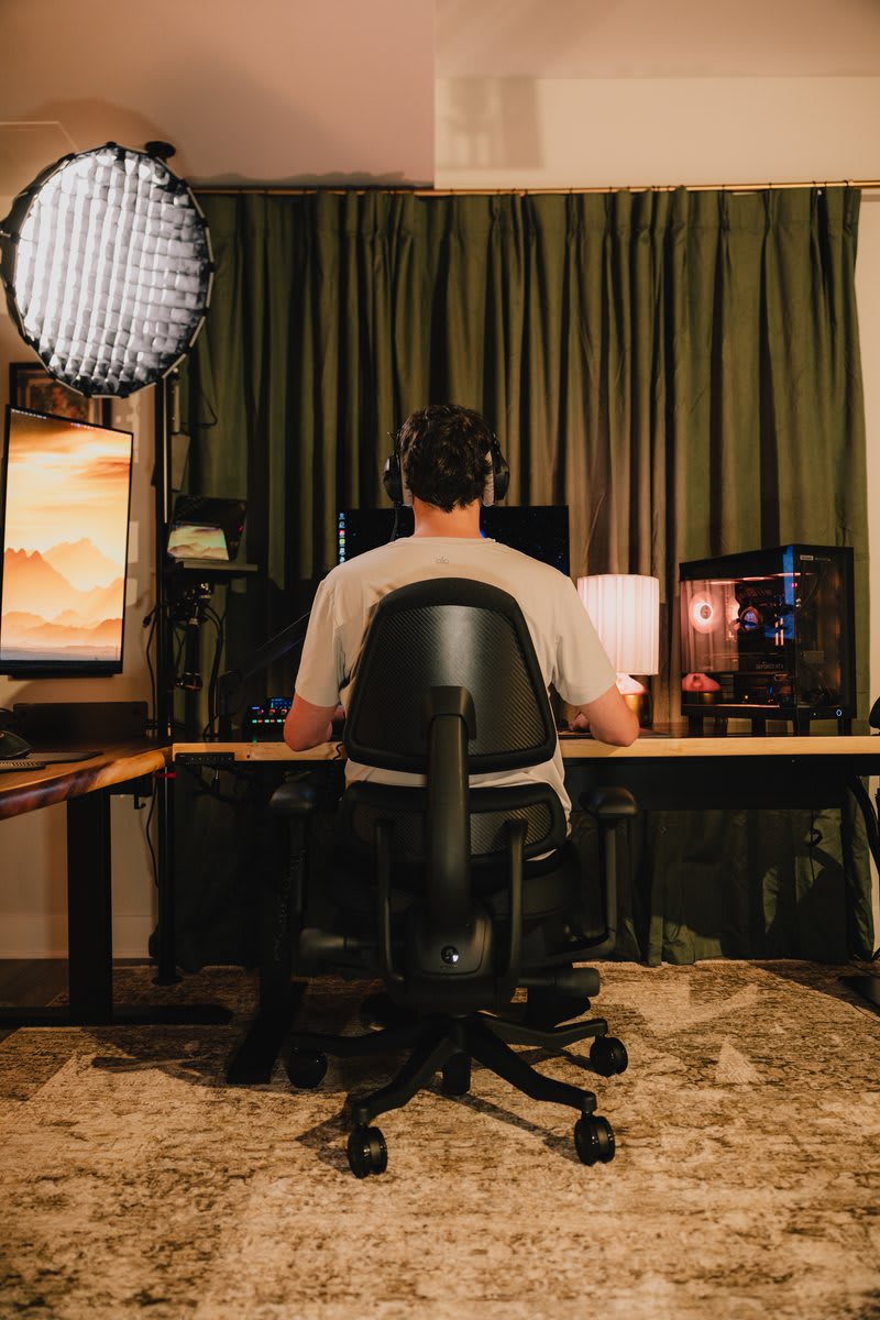 A person at a desk gently rolling their shoulders back, relieving tension in their neck and upper back during a long workday.