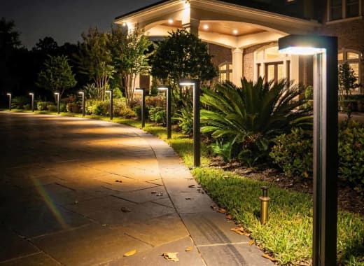 True Lumens™ solar bollard lights on a luxury home driveway at night