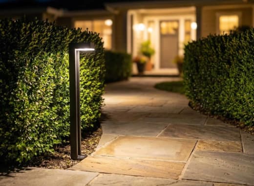 True Lumens™ solar bollard lights on a residential walkway and driveway at night