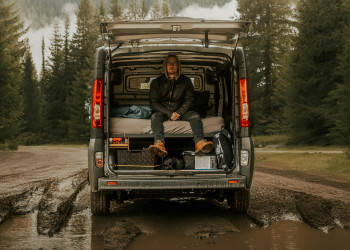 Man sits in campervan rear doors open garage misty mountain forest csegedi-joszef-2050570-22668381.jpg