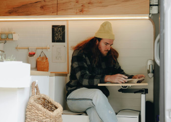 Man sits at table in campervan pnw-prod-9354539.jpg