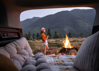 Woman stands campfire outside open rear doors getty-images-So0q-kTJgr0.jpg
