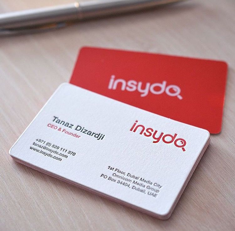 Close up of red and white luxury business cards with clean typography for a digital media CEO