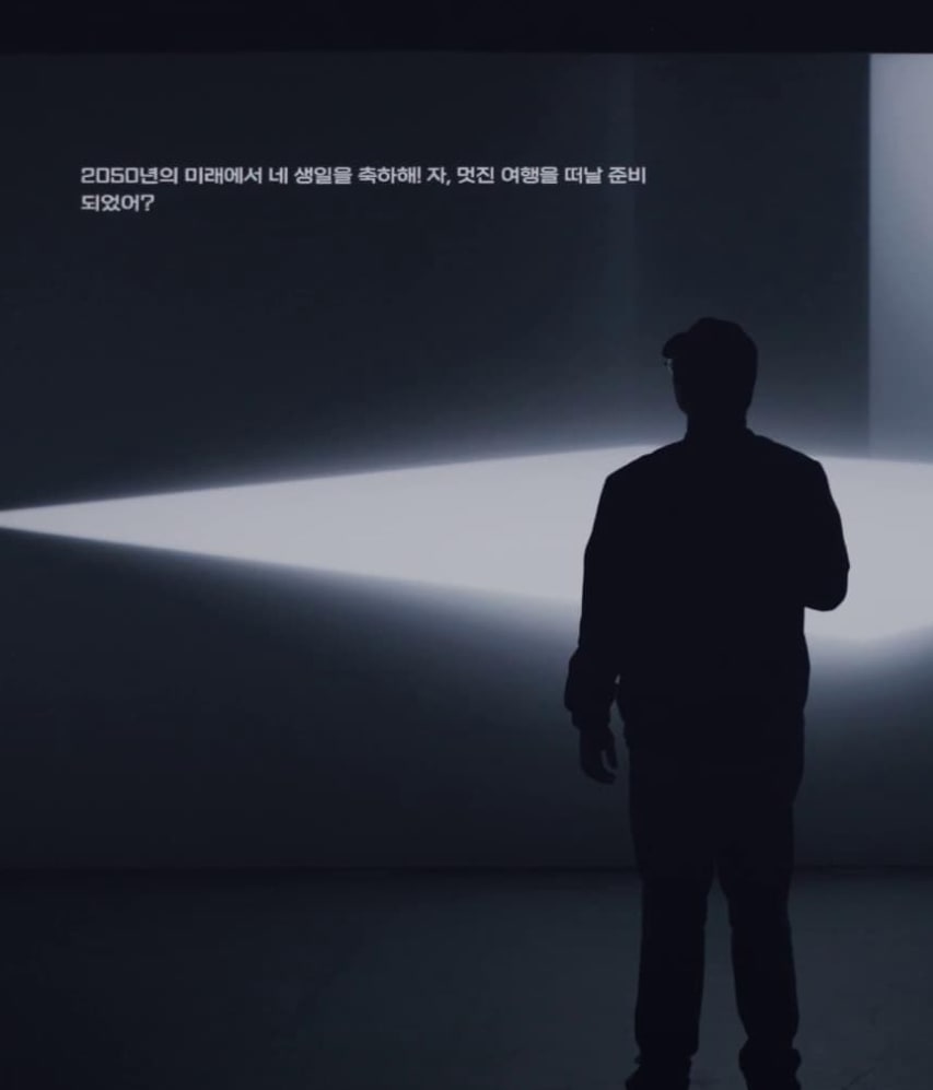 A participant faces a projected future in the installation.
