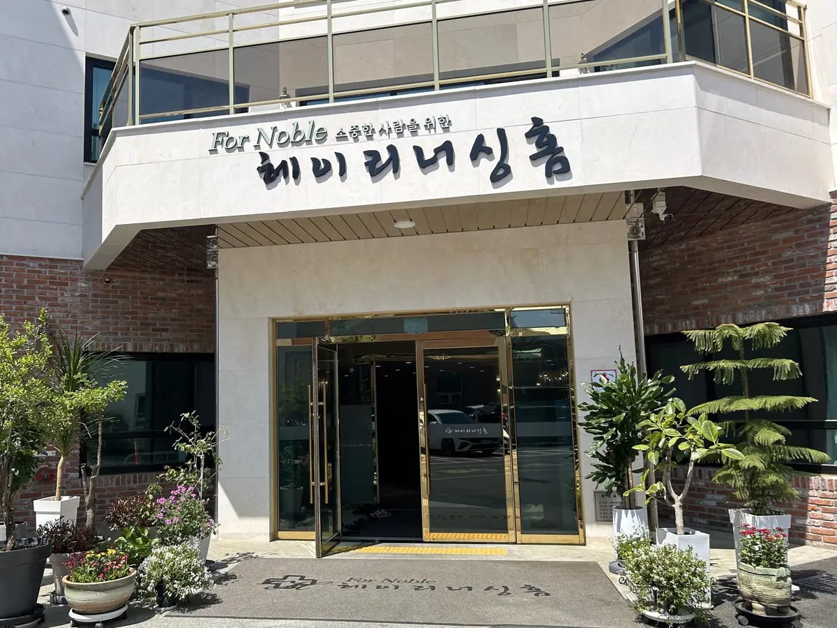 For Noble 헤이리너싱홈 간판과 금색 테 유리 출입문, 양옆 화분