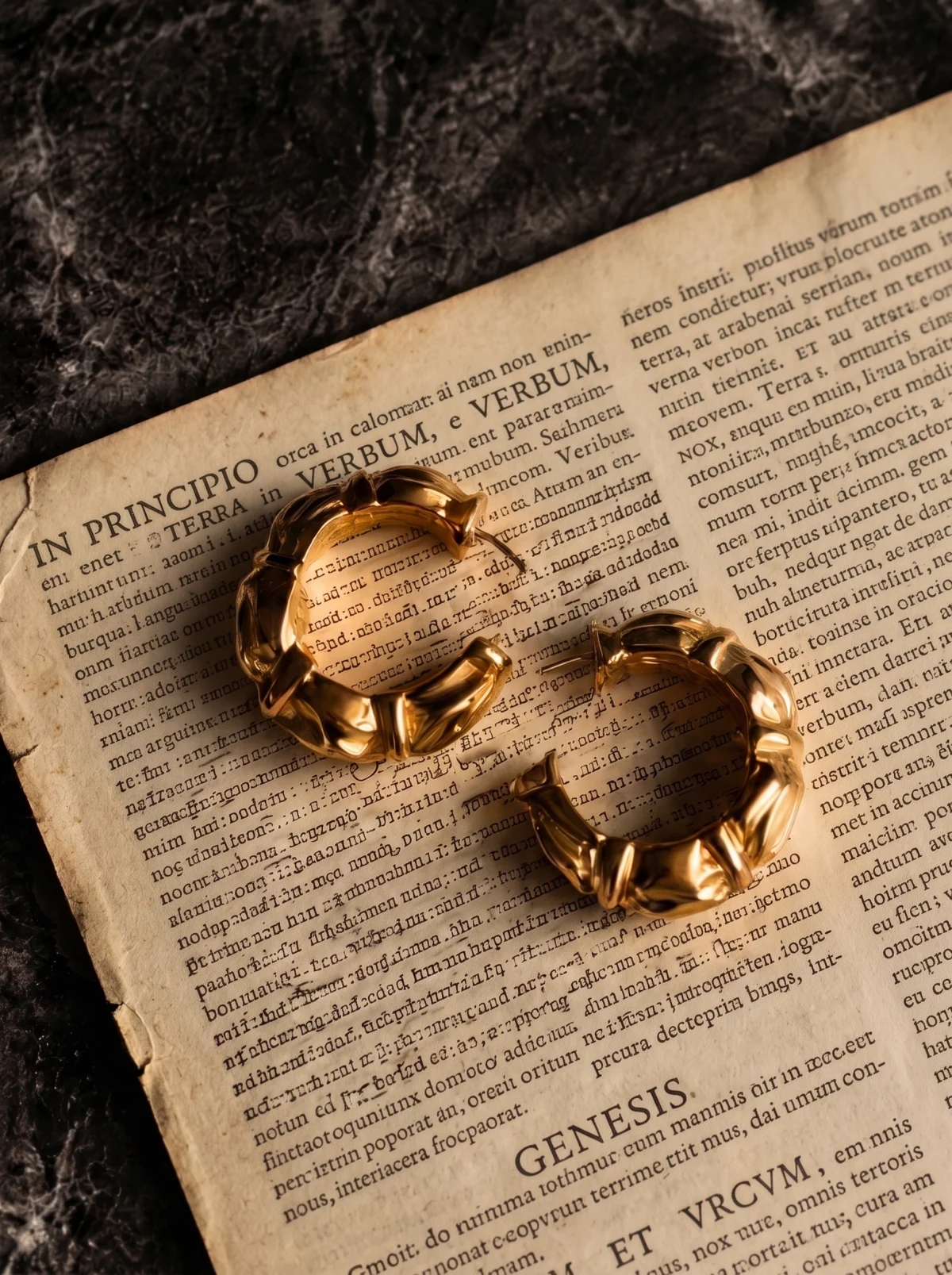 Pair of gold scalloped hoop earrings on an old book page, one turned to show its thickness