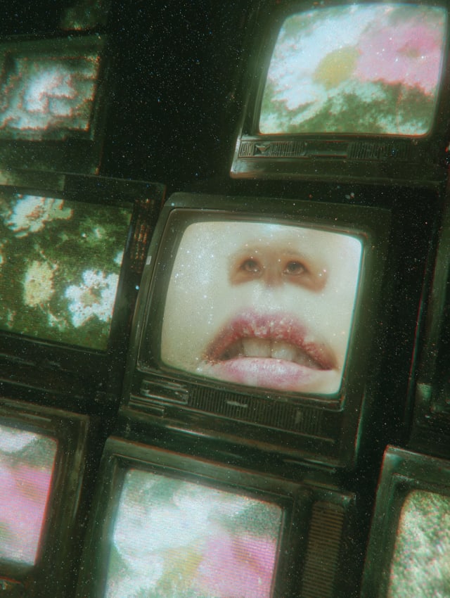 Stack of old television sets showing a close-up of lips and pink flowers