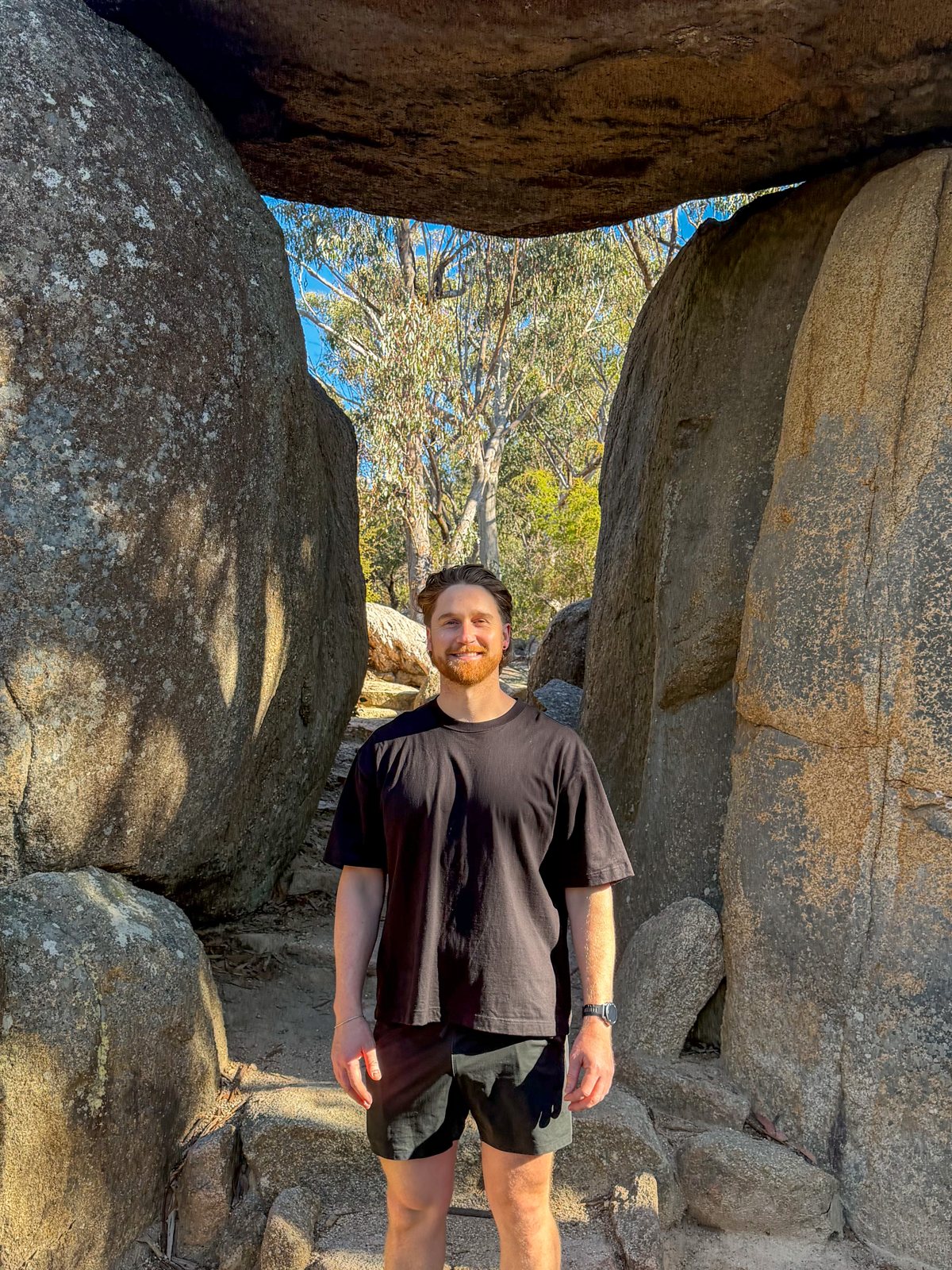 Toby Edmanson, who runs BRIS2032, standing among granite boulders in the Queensland bush