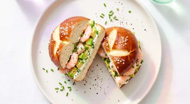 Photo de la recette Sandwich pain bretzel, crevettes et crémeux d'avocat, idée de déjeuner à 507 kcal par portion