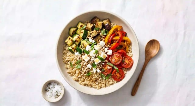 Photo de la recette Bol de quinoa et légumes d'été rôtis, feta et graines de tournesol, idée de déjeuner à 565 kcal par portion