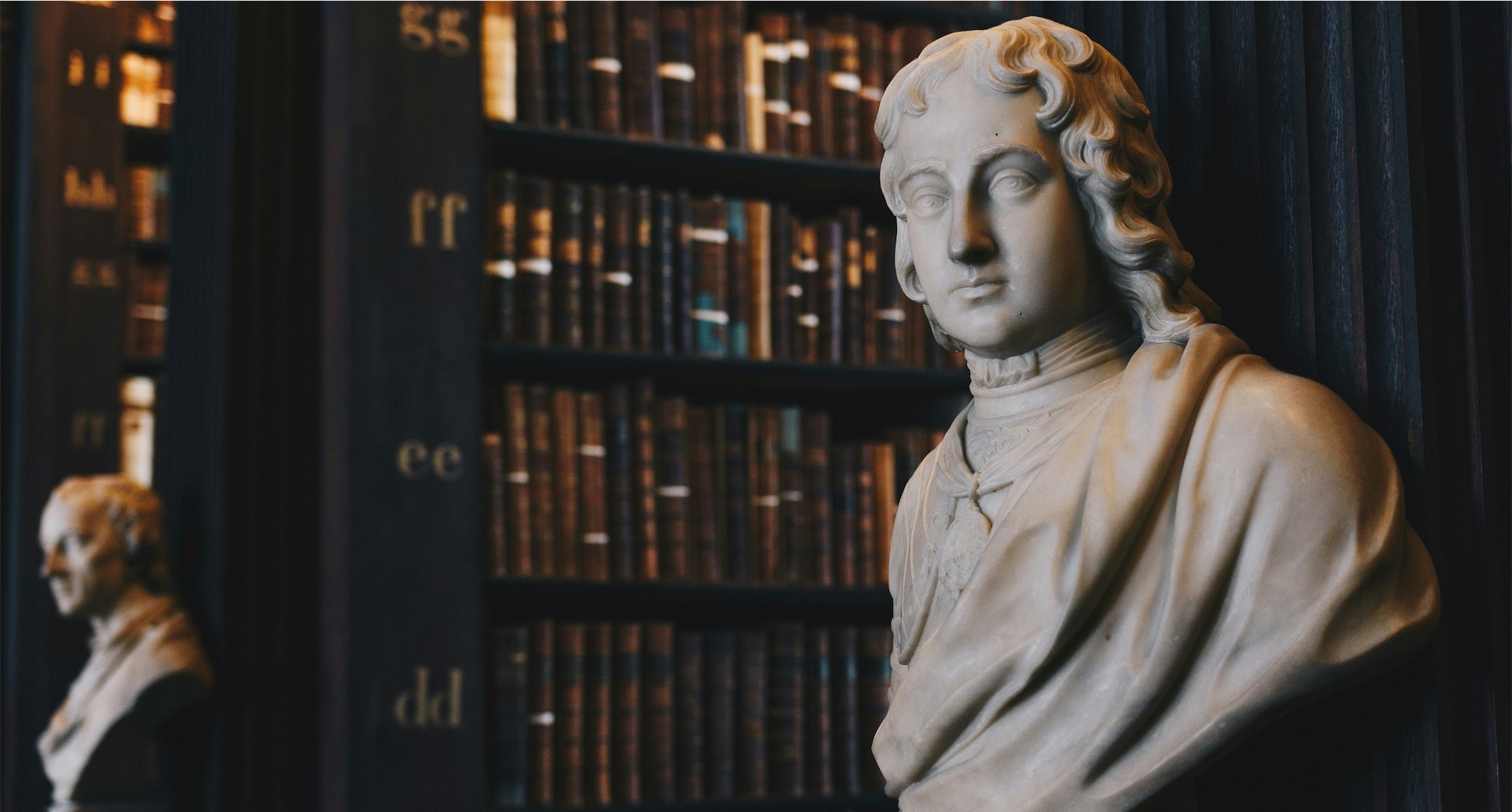 Man wearing robe bust figurine near black wall