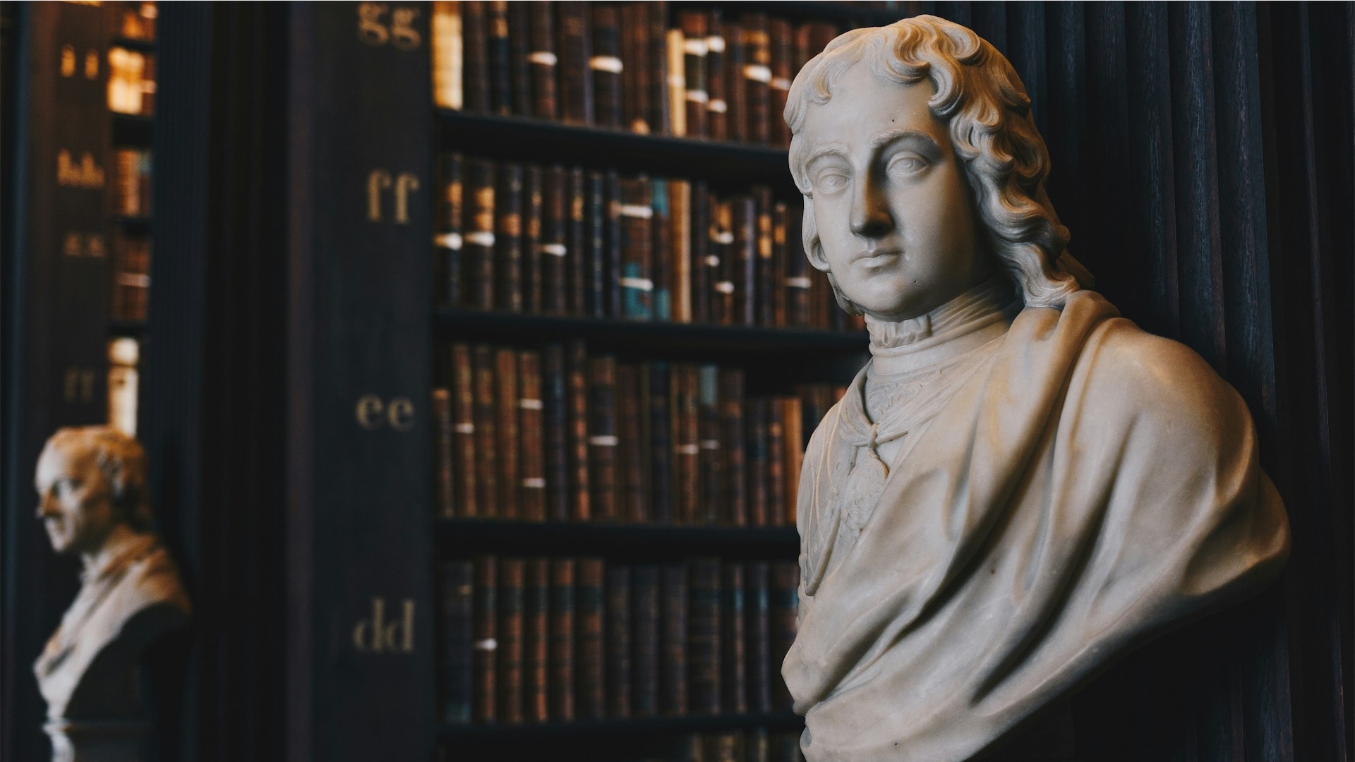 Man wearing robe bust figurine near black wall