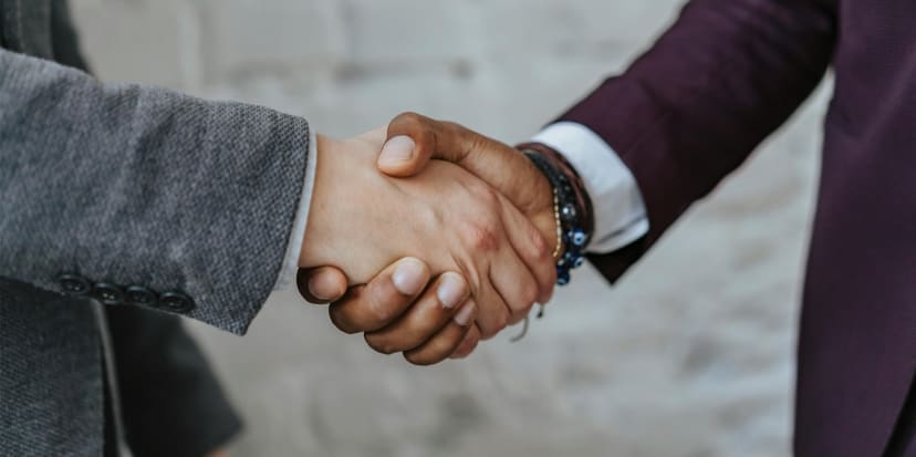 Handshake over legal documents representing settlement in debt claims