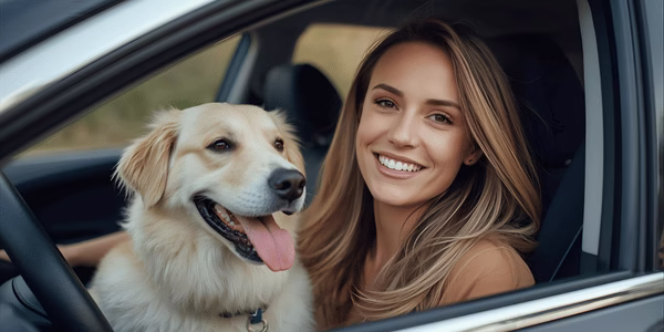 Owner smiling beside her relaxed dog in car after a calm and successful ride.