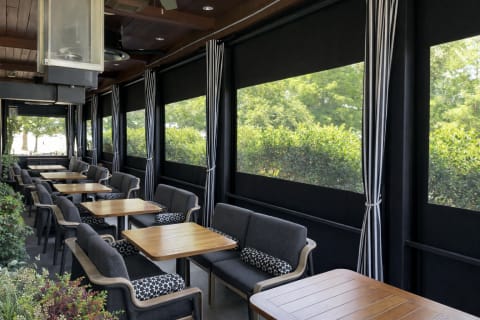 Motorized screen system on upscale restaurant outdoor seating area