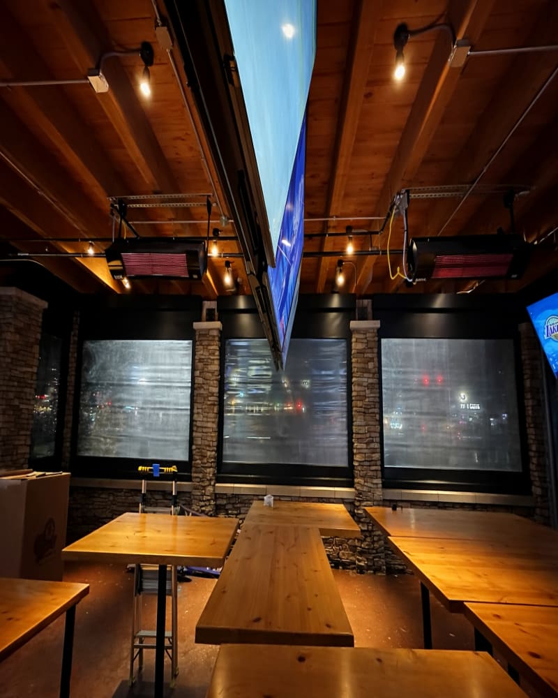 Restaurant patio with V-Track motorized screens deployed for evening service