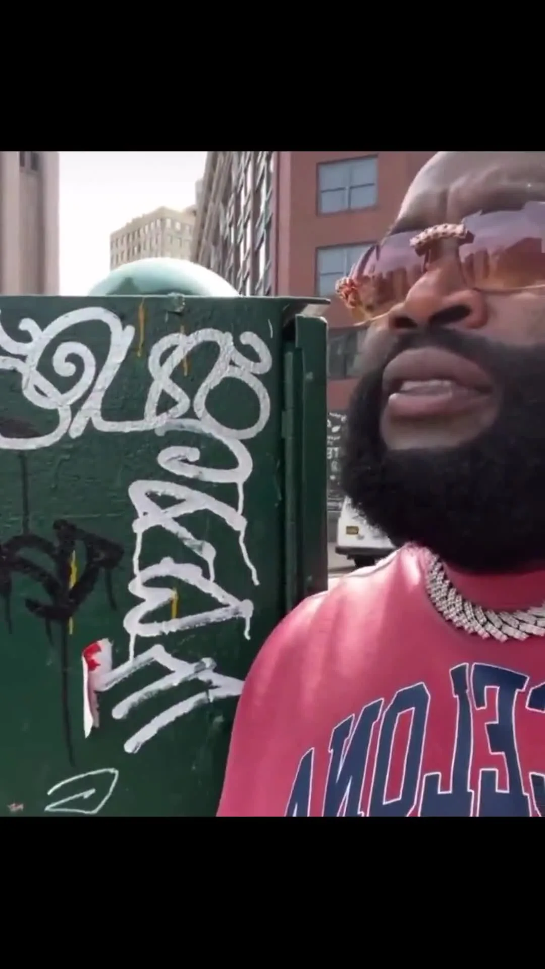 Rick Ross unbothered holding sign on street