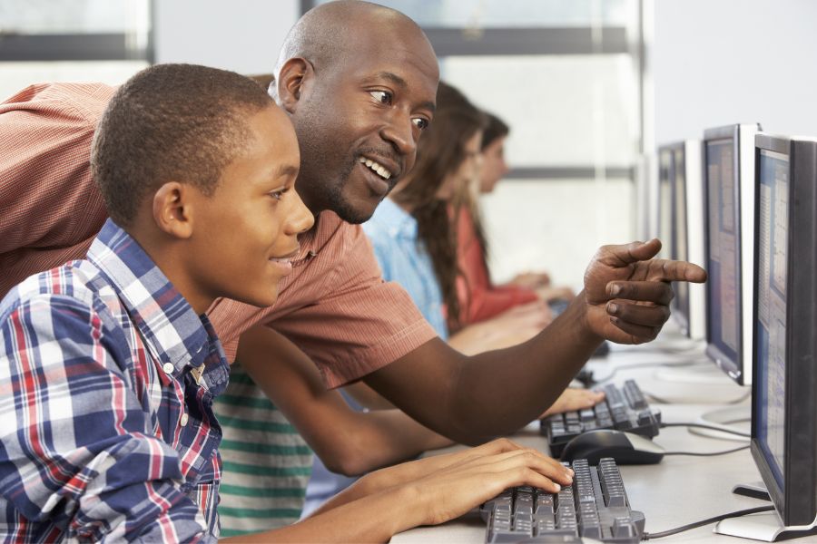 Learner receiving academic support from a teacher, mitigating the risk of drop out