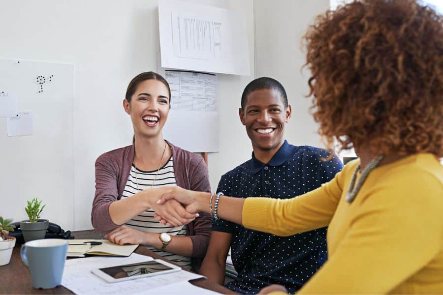 people shaking hands after signing job contracts