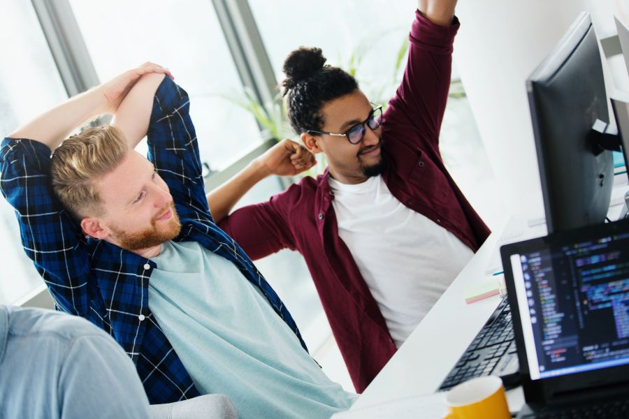 students stretching at their desk while studying