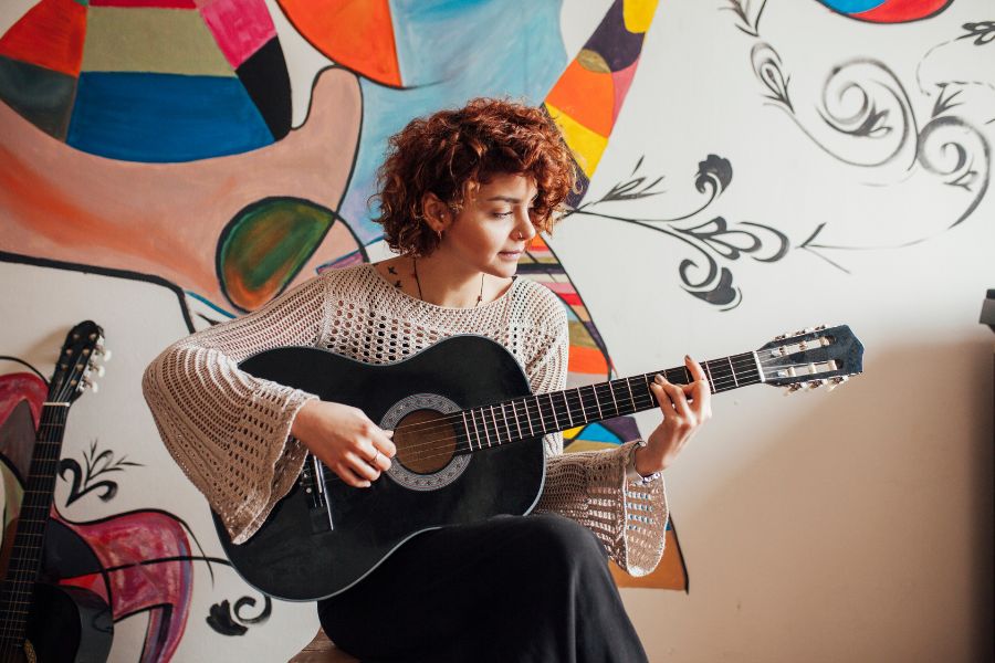 student learning how to play guitar during school holidays