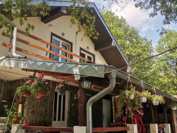 Spoljašnost apartmana sa tremom, visećim cvećem i zelenilom