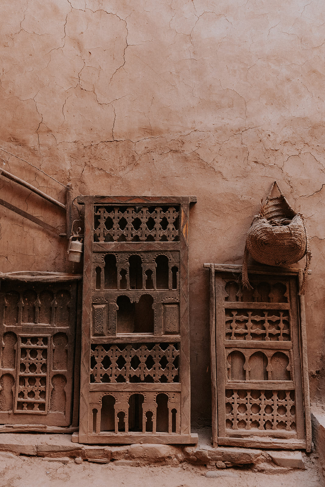 A detail of an old pisé wall surface showing the texture of compacted earth, small visible aggregates and flecks of straw, soft warm earth-tone palette, photorealistic editorial photography, soft even natural daylight, no people, intimate architectural detail, premium publication aesthetic, 4:5