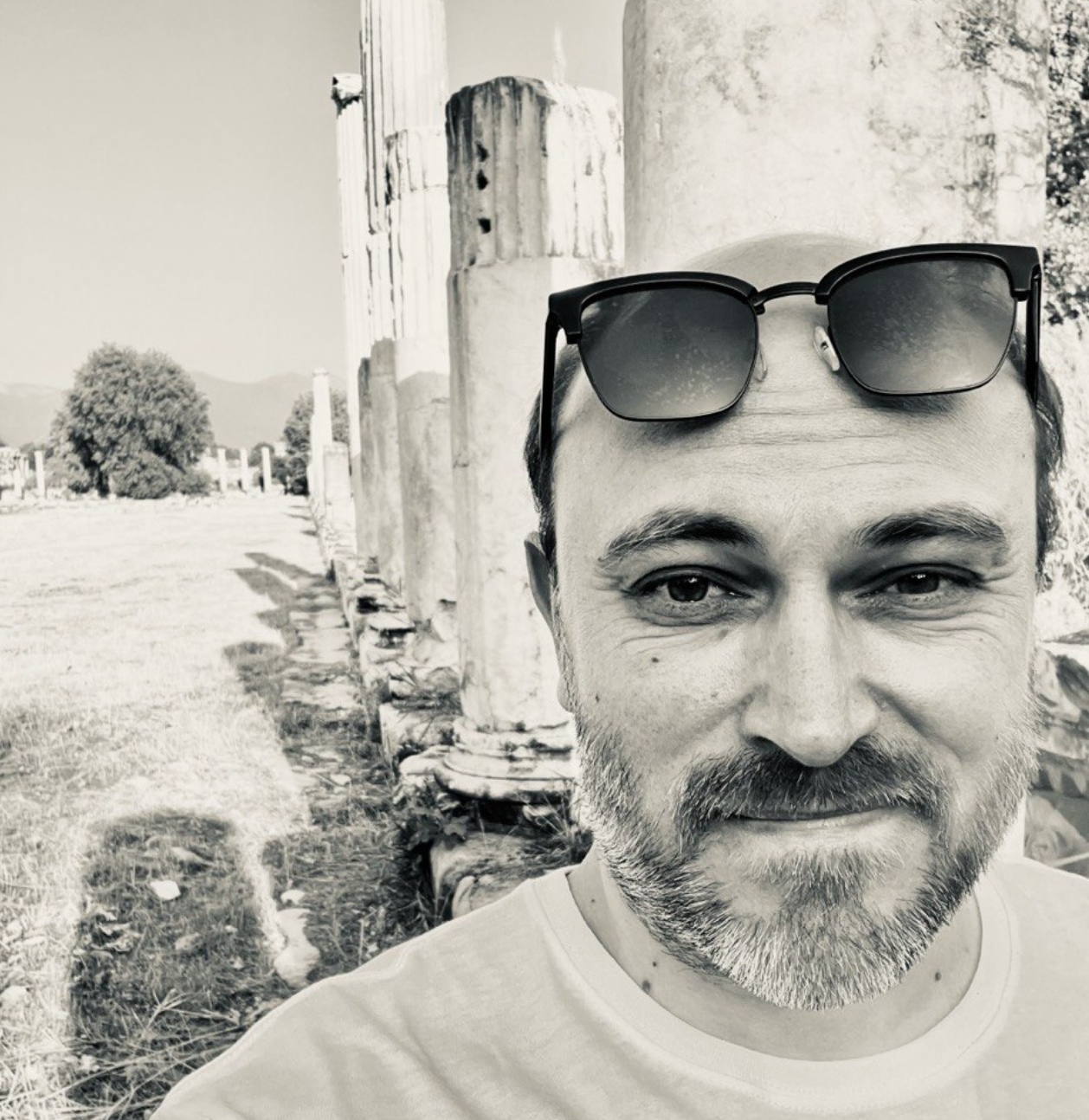 Arkadiy Avdokhin at an archaeological site, with the colonnade and ancient remains visible