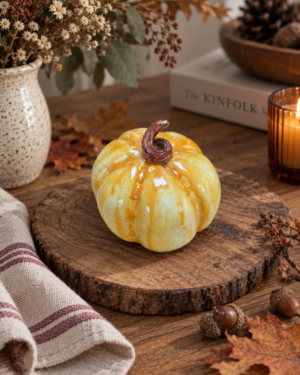 Handmade yellow ceramic pumpkin with a glossy golden glaze and curled stem. Unique autumn home decor and a charming handmade seasonal gift.