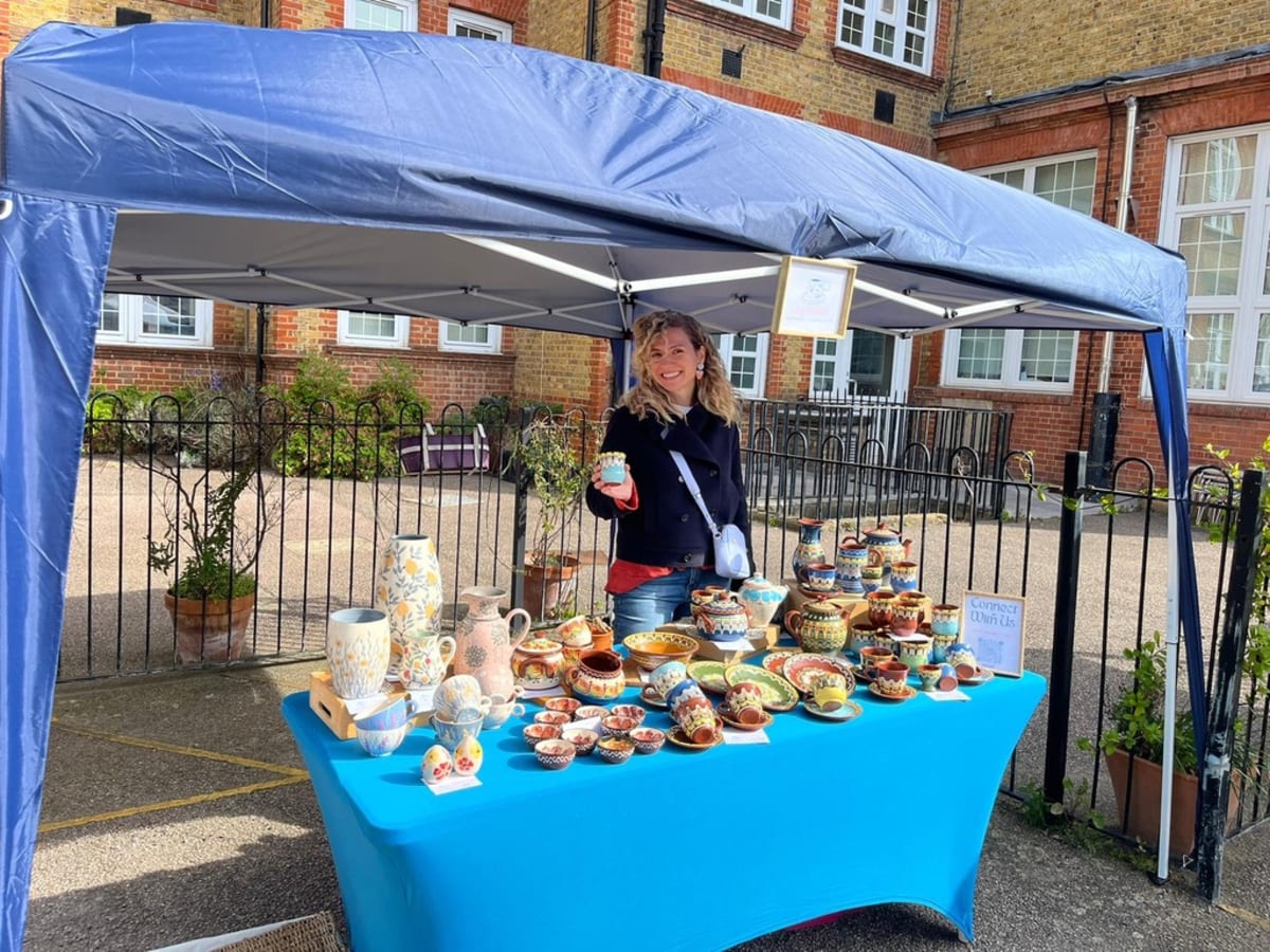 InchyArt handmade ceramics displayed at an artisan market stall with risers and wooden crates