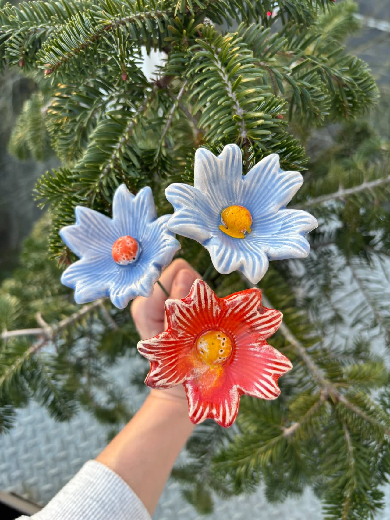 Set of three colourful ceramic flowers on green metal stems, each individually sculpted and hand-glazed