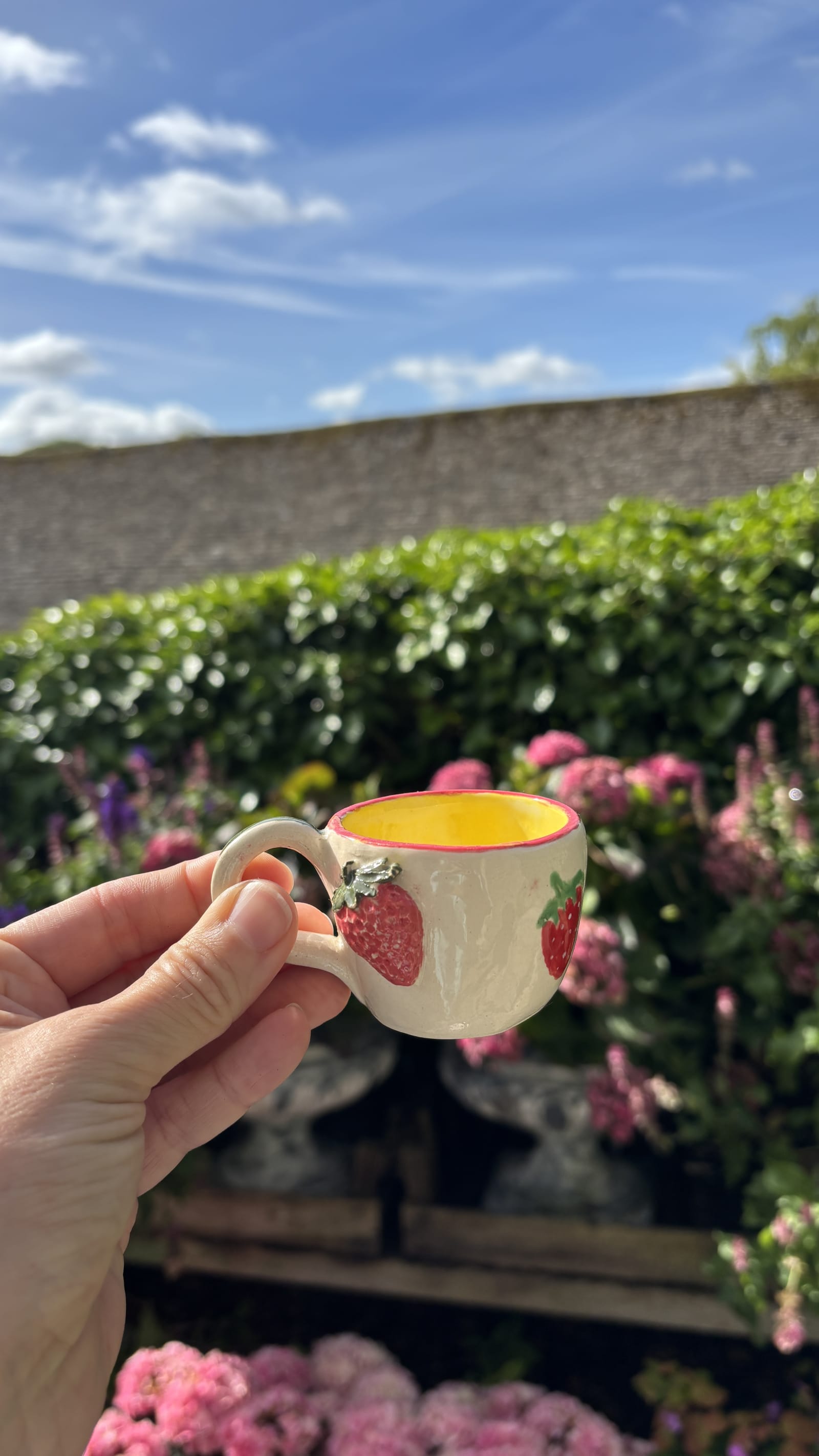 Mini ceramic espresso cup with hand-painted red strawberry pattern and bright yellow glazed interior