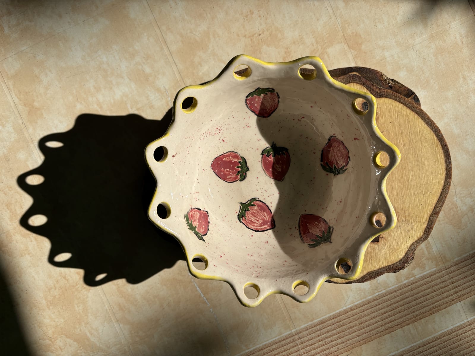 Handmade cream ceramic bowl with painted strawberries and a yellow scalloped rim.