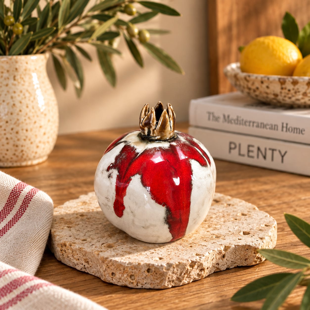 Handmade red and white ceramic pomegranate with a glossy glaze and sculptural crown. Unique decorative pottery symbolising love, abundance and new beginnings.