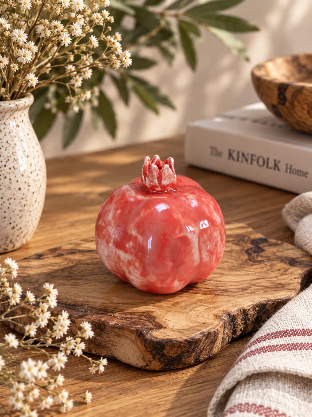 Handmade coral red ceramic pomegranate with a glossy glaze and sculptural crown. Unique decorative pottery symbolising love, abundance and new beginnings.