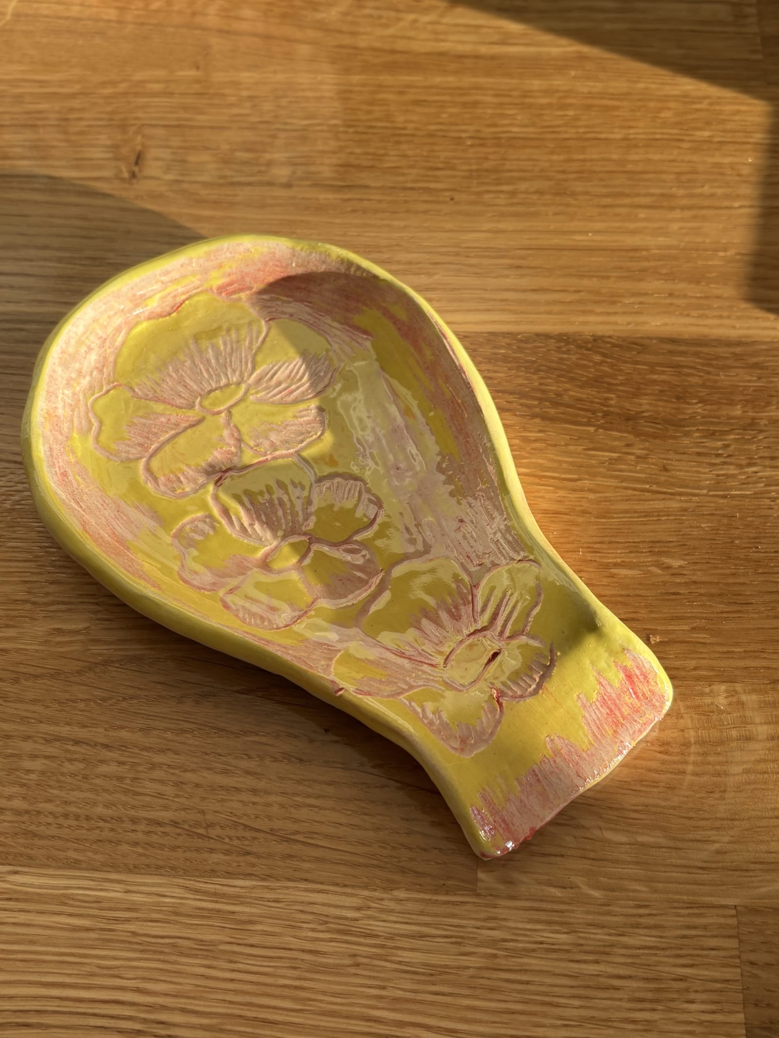 Handmade yellow ceramic spoon rest with pink floral design