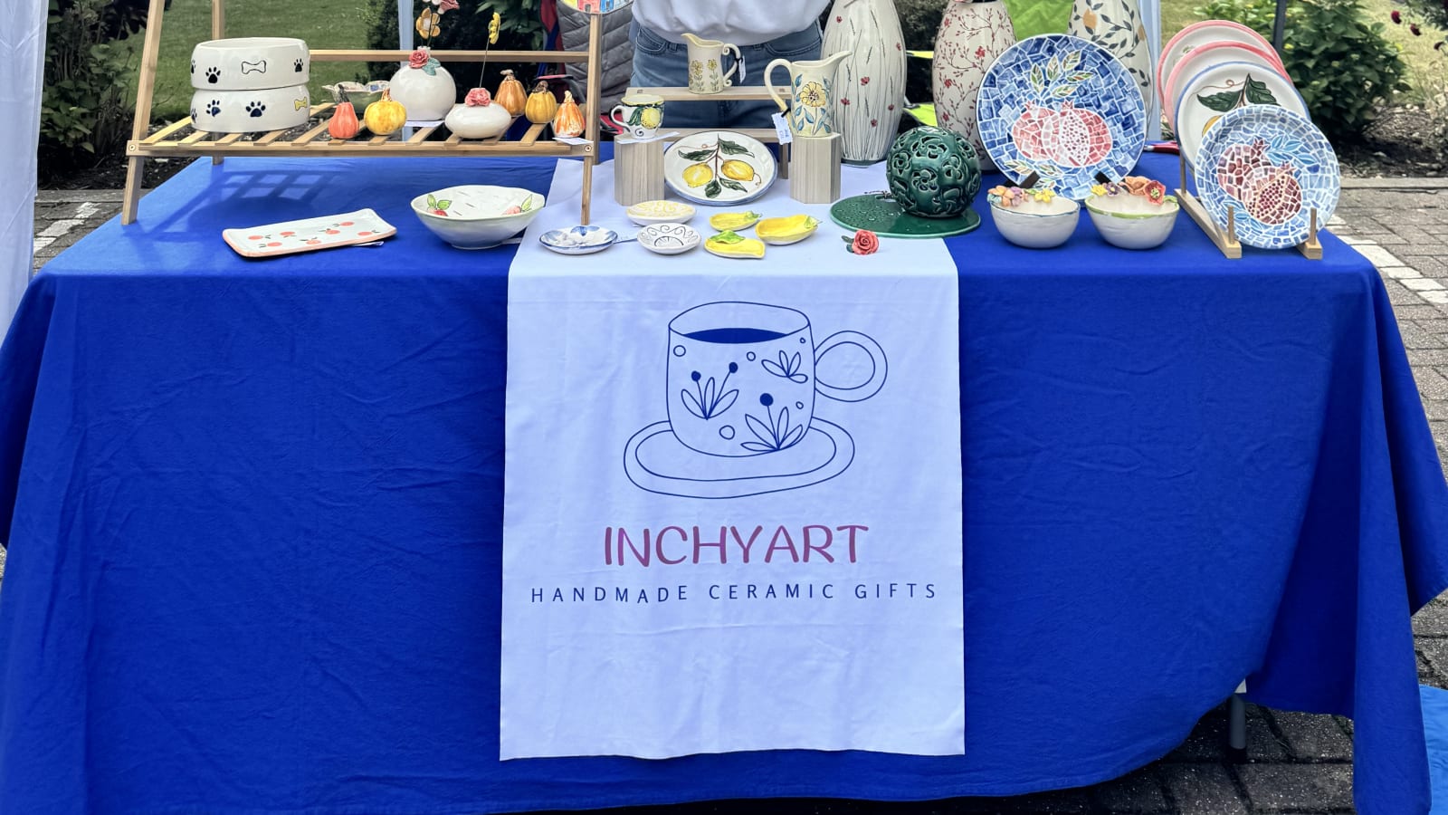 The InchyArt stall set up at an artisan market with handmade ceramics on display