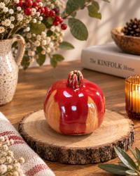 Handmade red ceramic pomegranate with a glossy red and earthy glaze. Unique decorative pottery symbolising love, abundance and new beginnings.